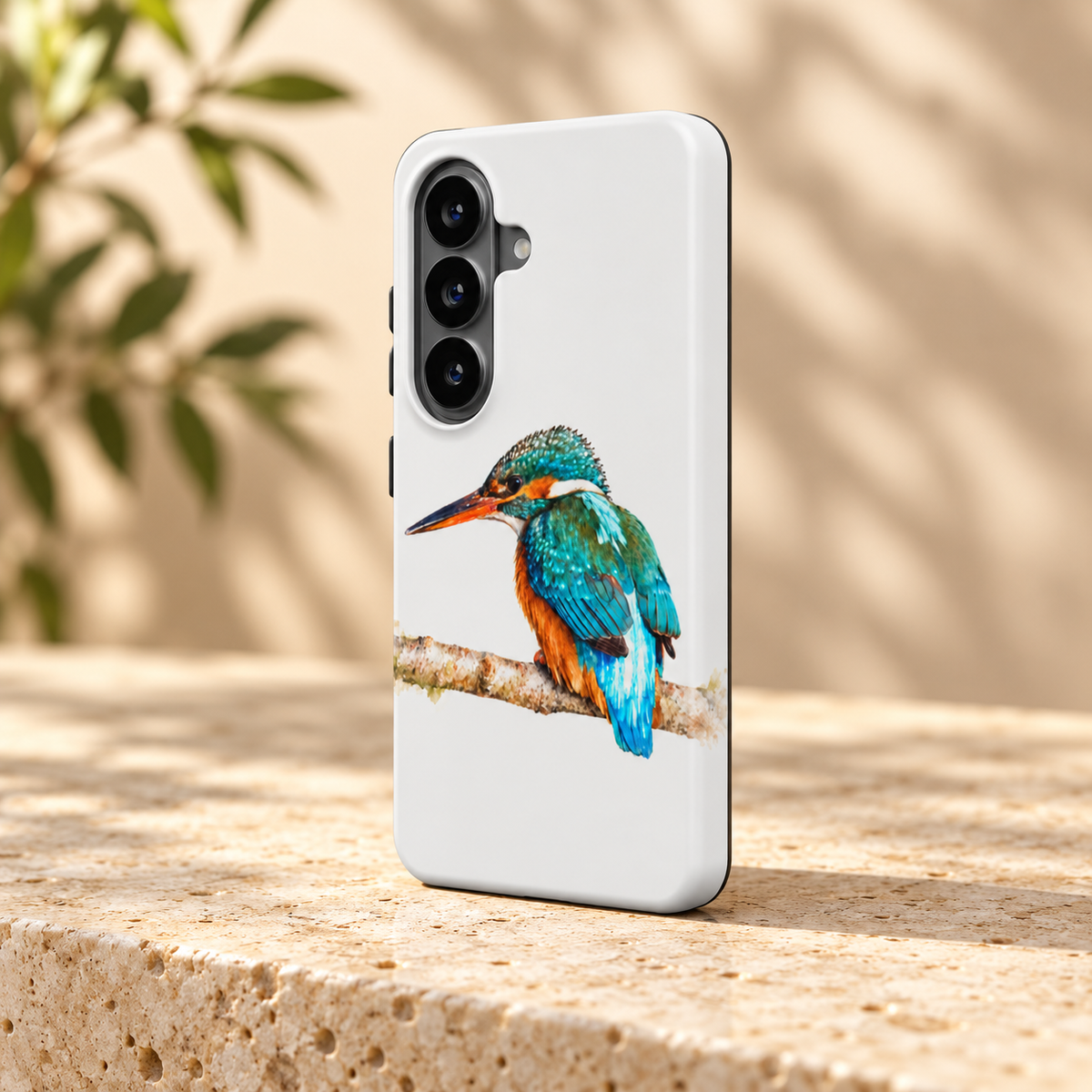 Wit Samsung-hoesje met IJsvogel in aquarelstijl, schuin van achteren op een lichte stenen ondergrond.