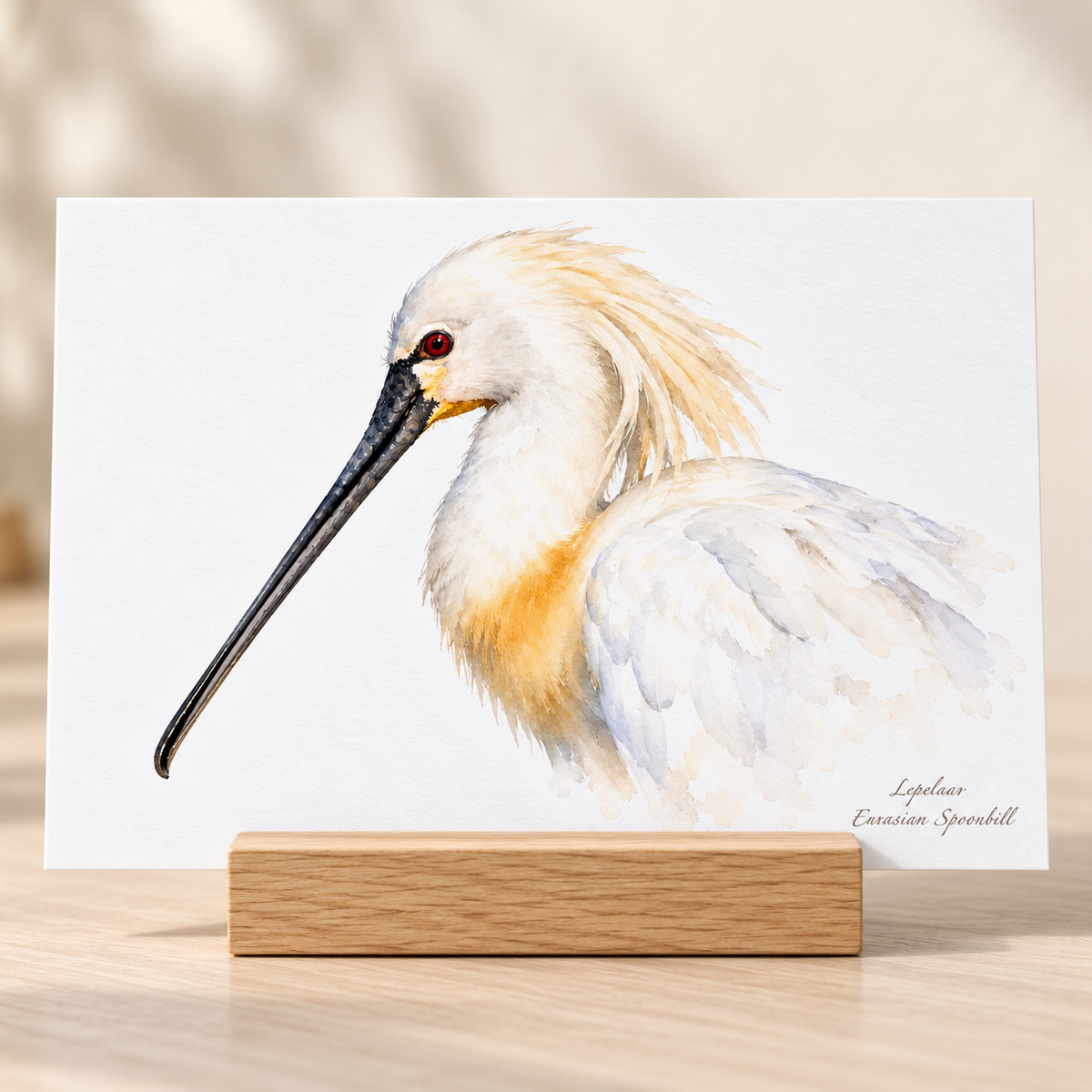 Briefkaart met een lepelaar in aquarelstijl in een houten kaarthouder op tafel