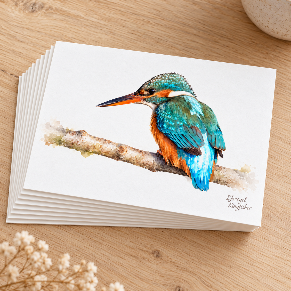 Stapel liggende briefkaarten met een ijsvogel in aquarelstijl op een houten tafel